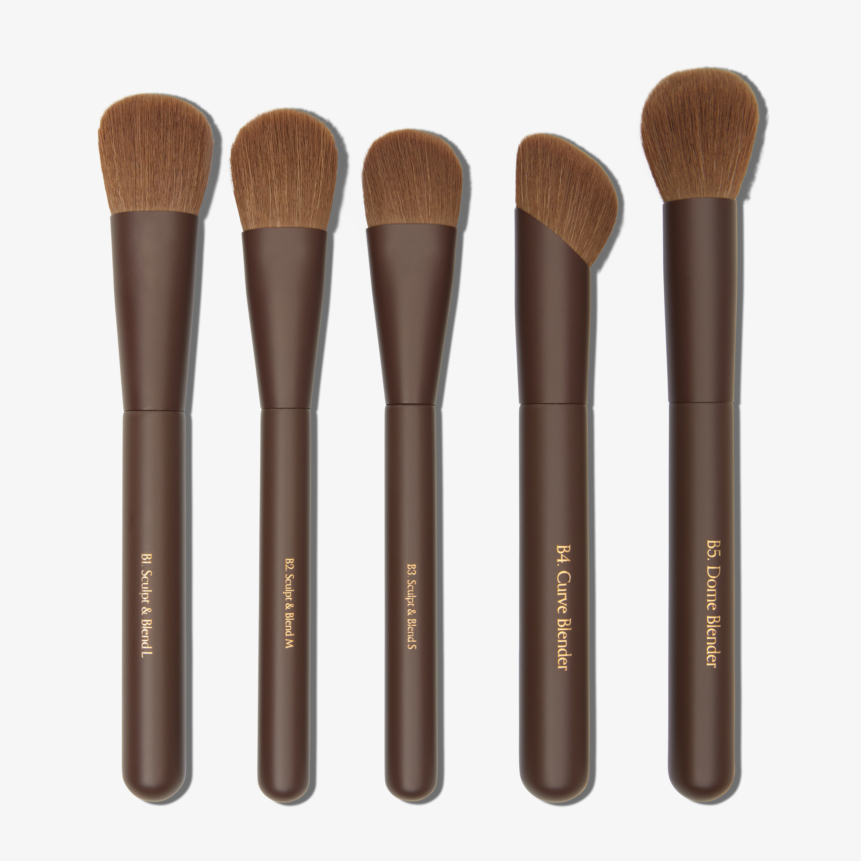 A selection of five brown makeup brushes to choose from with synthetic brown bristles and brown handles, labeled with their intended use.