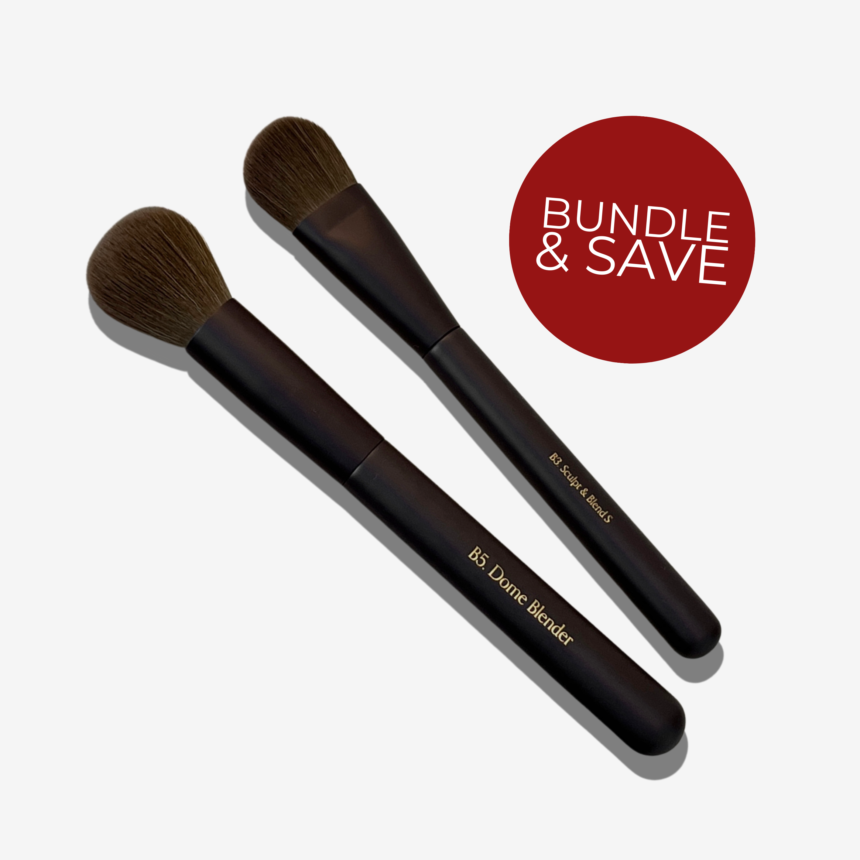 A set of two makeup brushes with brown bristles and handles. A red dot says 'BUNDLE & SAVE'