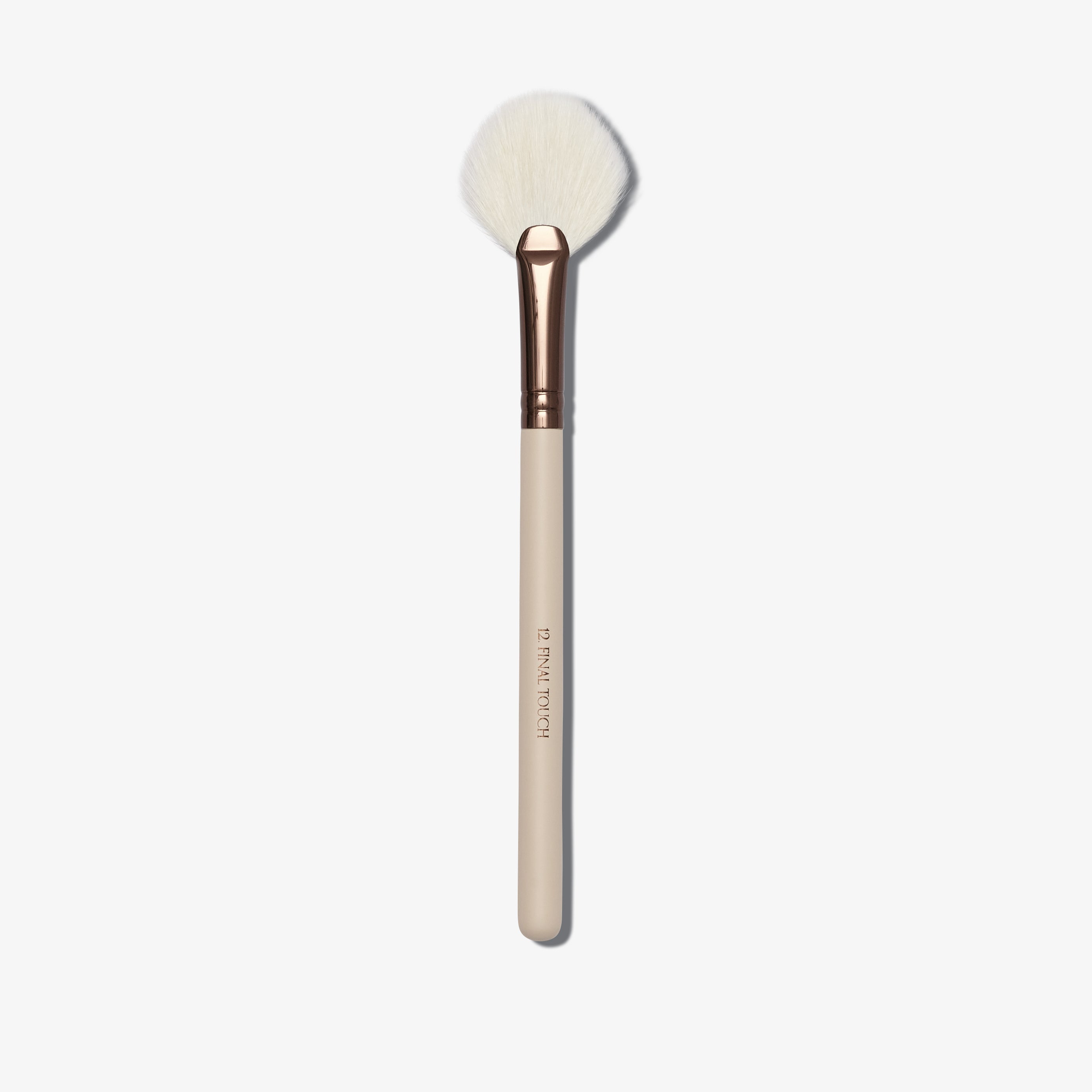 A cream coloured fan shaped makeup brush with white brush hairs 