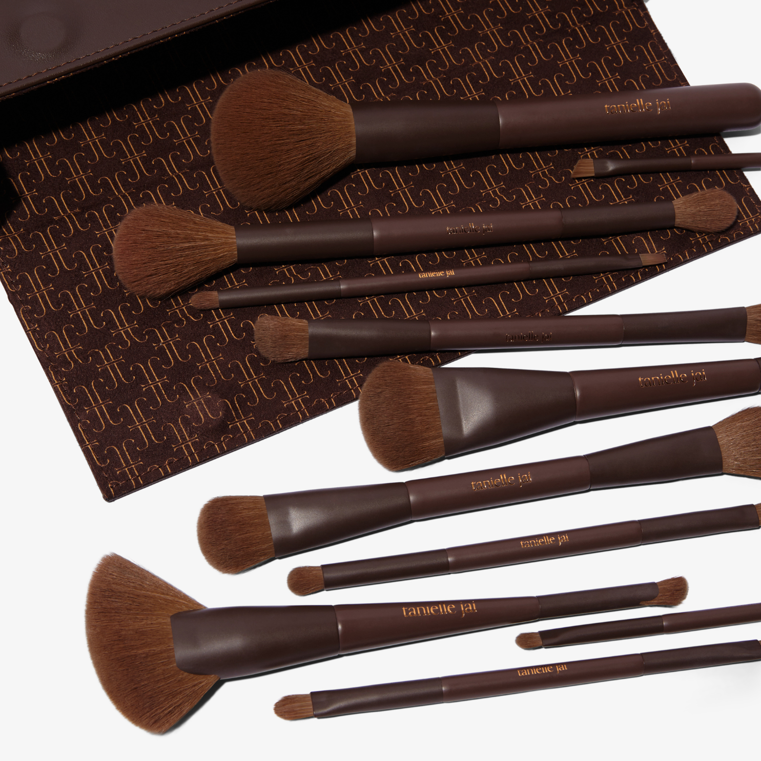 A set of 11 makeup brushes with brown handles and hypoallergenic synthetic bristles, displayed alongside a brown vegan magnetic brush clutch.
