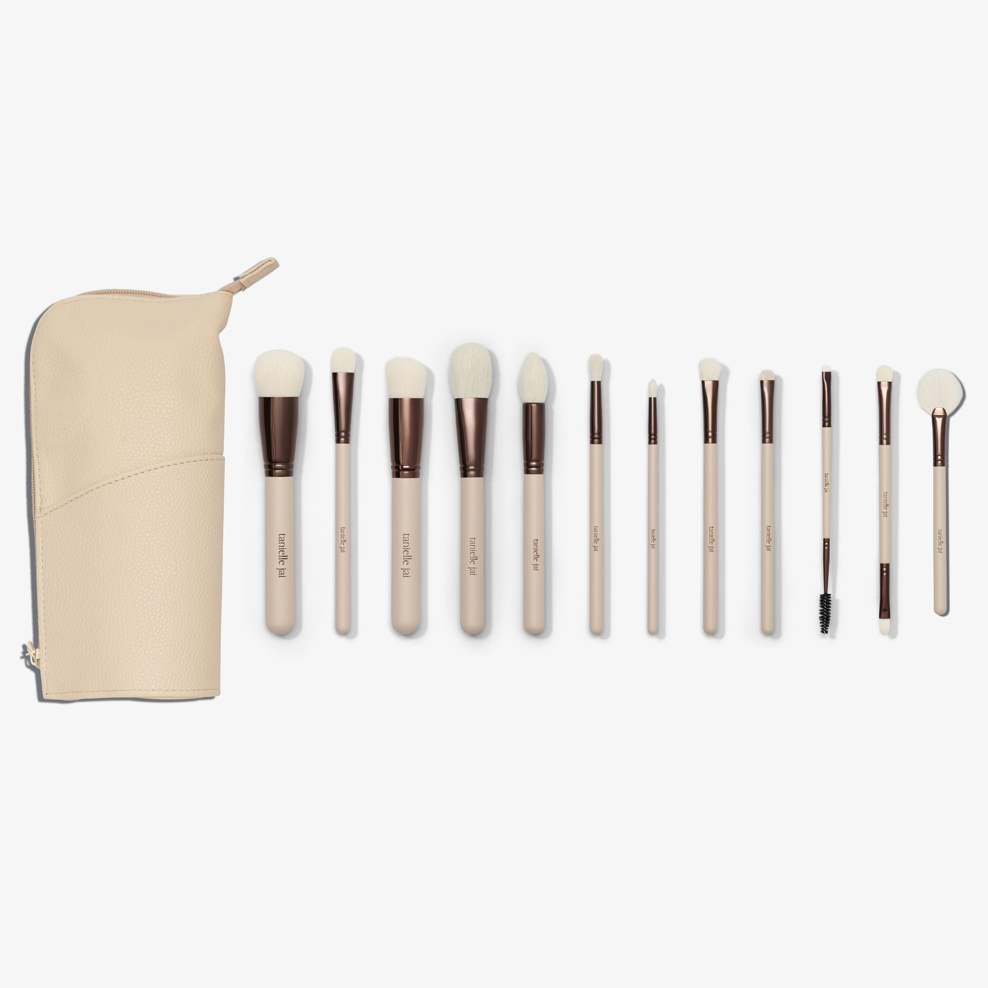 A set of twelve makeup brushes with beige handles and white bristles, displayed alongside a cream vegan leather case. 